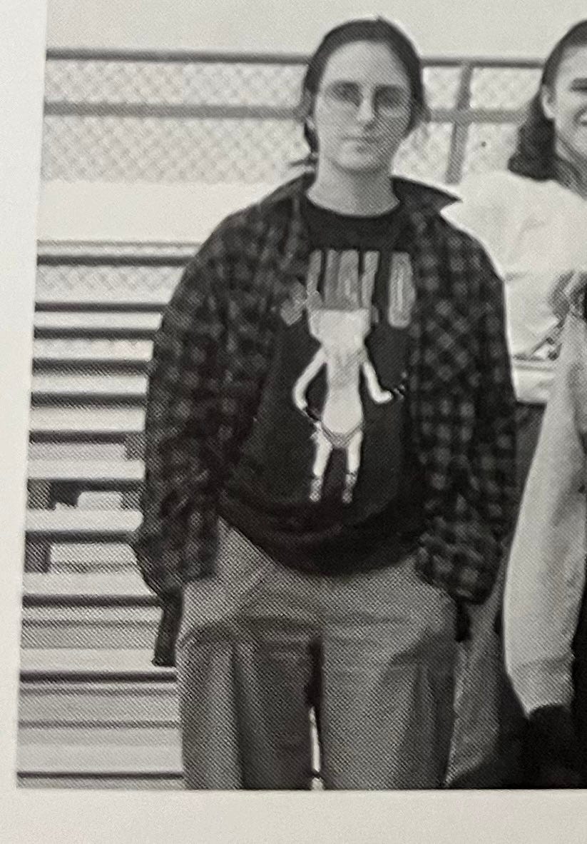 Me at 16 or 17 or so -- glasses, hair back in a bun, t-shirt with Beavis on it, flannel over that, hands in my pockets, looking kinda over it