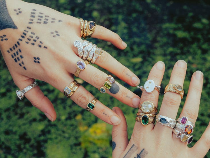 Two hands wearing many rings
