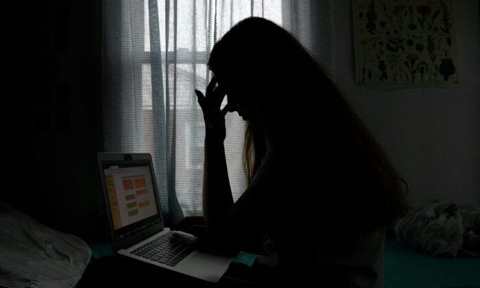 A teenager with a laptop in Arlington, Va., on June 11, 2021. (OLIVIER DOULIERY/AFP via Getty Images)