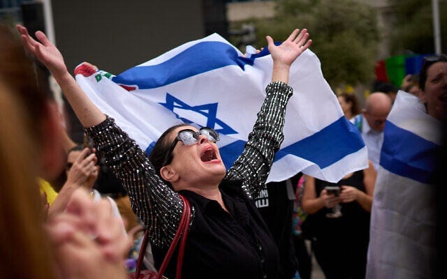 People react as they celebrate following the announcement that Israel and Hamas have agreed to the first phase of a peace plan to pause the fighting, at Hostages Square in Tel Aviv, Oct. 9, 2025. (AP Photo/Emilio Morenatti)