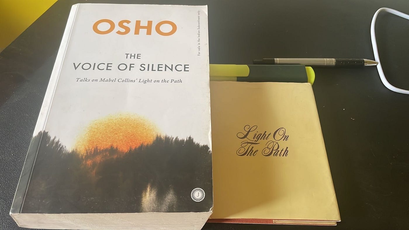 Osho’s The Voice Of Silence and Mabel Collins’ Light On The Path lying side by side on a black desk