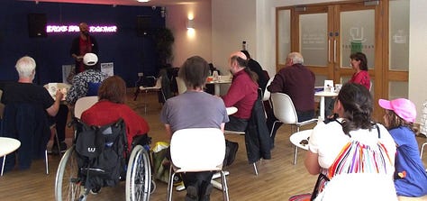 9 images from literary events in Medway. People reading from their books, people watching writers reading from their books. 