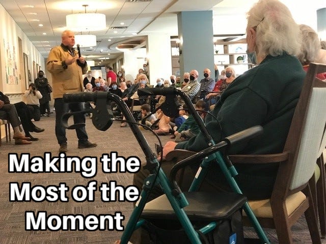 Minnesota Governor Tim Walz visits a group of seniors. A woman with gray hair and a walker is in the foreground. Inset caption: “Making the Most of the Moment.“ Minnesota Governor Tim Walz visits a group of seniors. A woman with gray hair and a walker is in the foreground. Inset caption: “Making the Most of the Moment.“