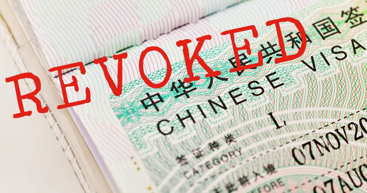 A close-up of a Chinese visa inside a passport with the word "REVOKED" stamped in red across the page, symbolizing exit bans and travel restrictions. A close-up of a Chinese visa inside a passport with the word "REVOKED" stamped in red across the page, symbolizing exit bans and travel restrictions.