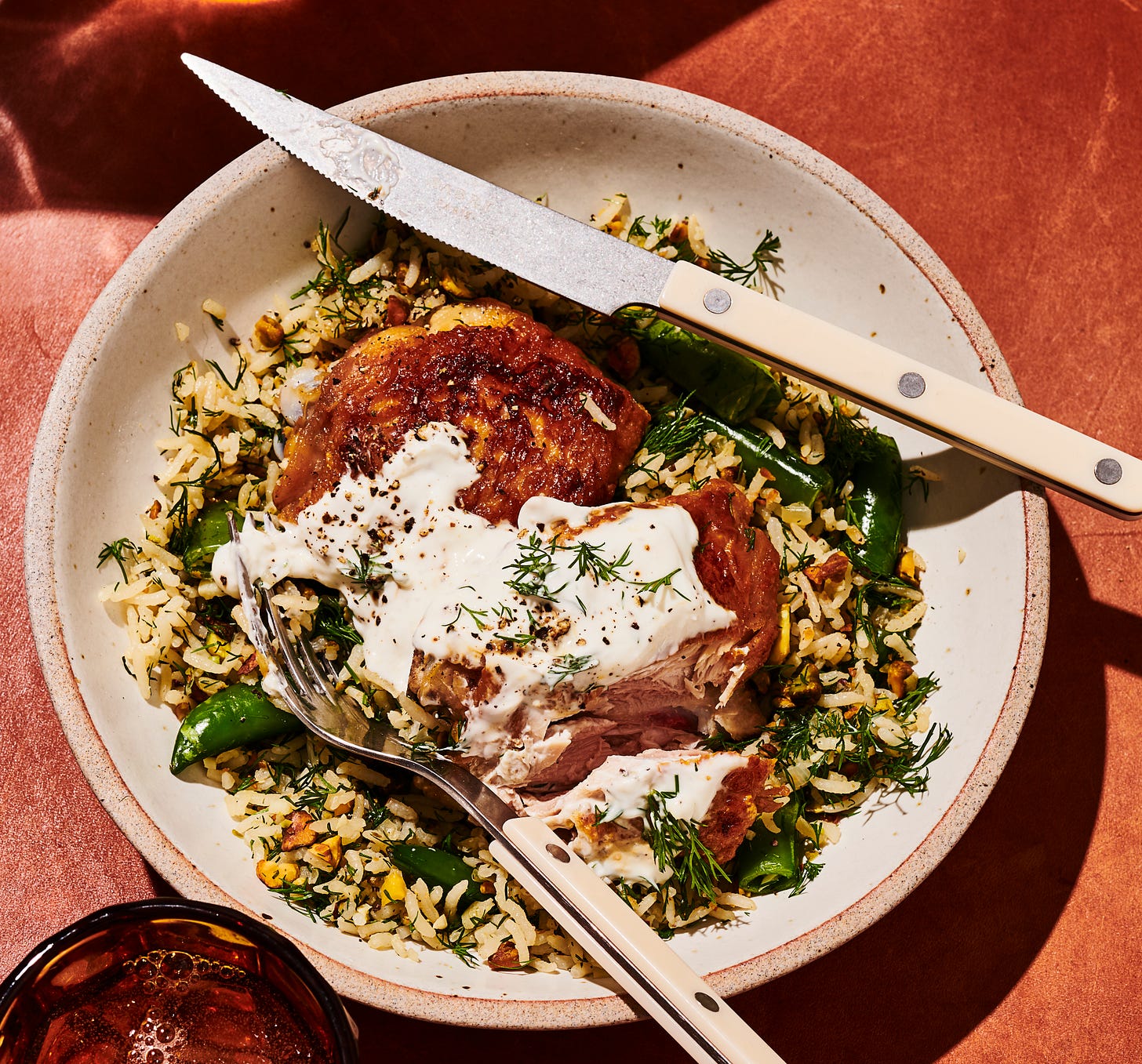 Chicken and rice with knife and fork.