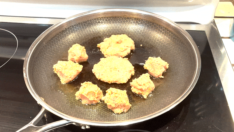 Sizzling hot dog patties and meatballs.