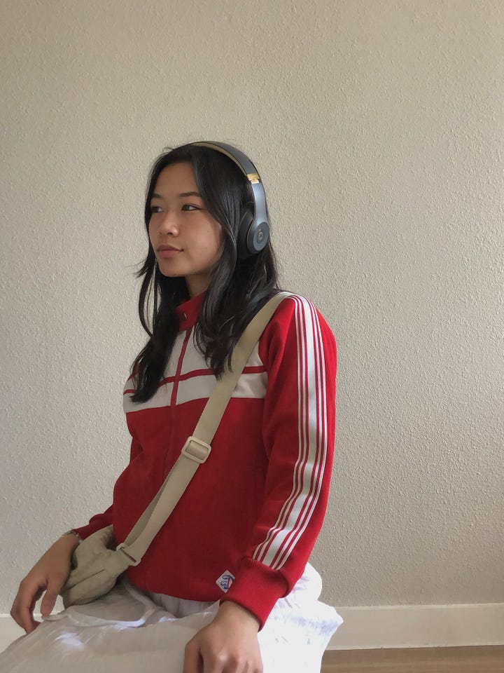 On the left is an image of Jenn and her boyfriend standing on a rooftop while Jenn is taking a photo of the skyline as fireworks erupt on New Years. On the right is an image of Jenn looking off to the left wearing a red and white jacket and headphones.