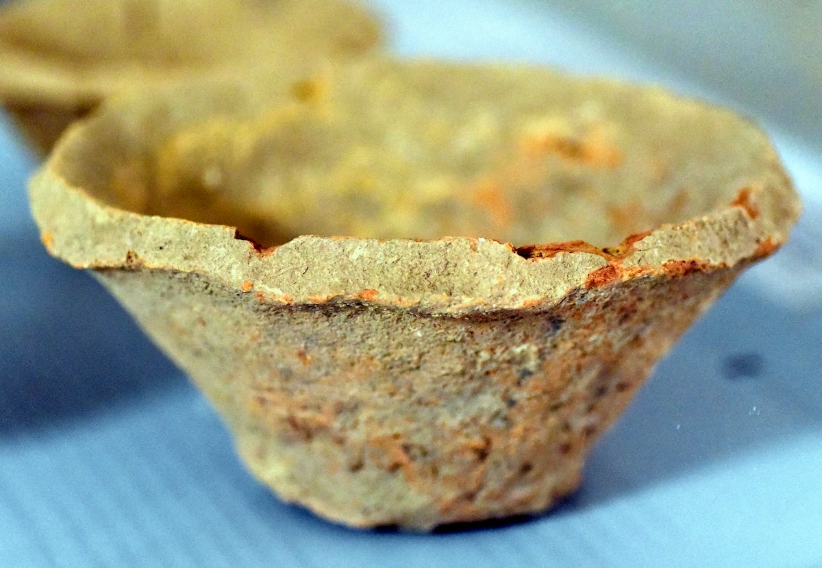 A crude bowl with a narrow base and wider rim that is beveled as if cut quickly with a knife. It’s really rough. A crude bowl with a narrow base and wider rim that is beveled as if cut quickly with a knife. It’s really rough.