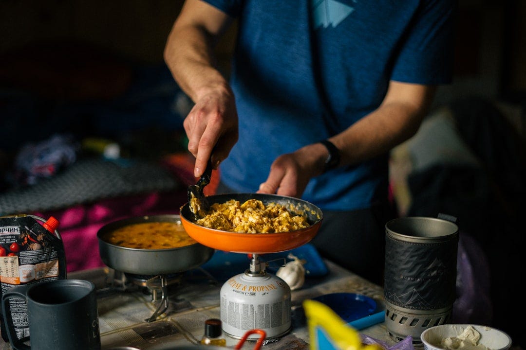 a person cooking food in a wok a person cooking food in a wok