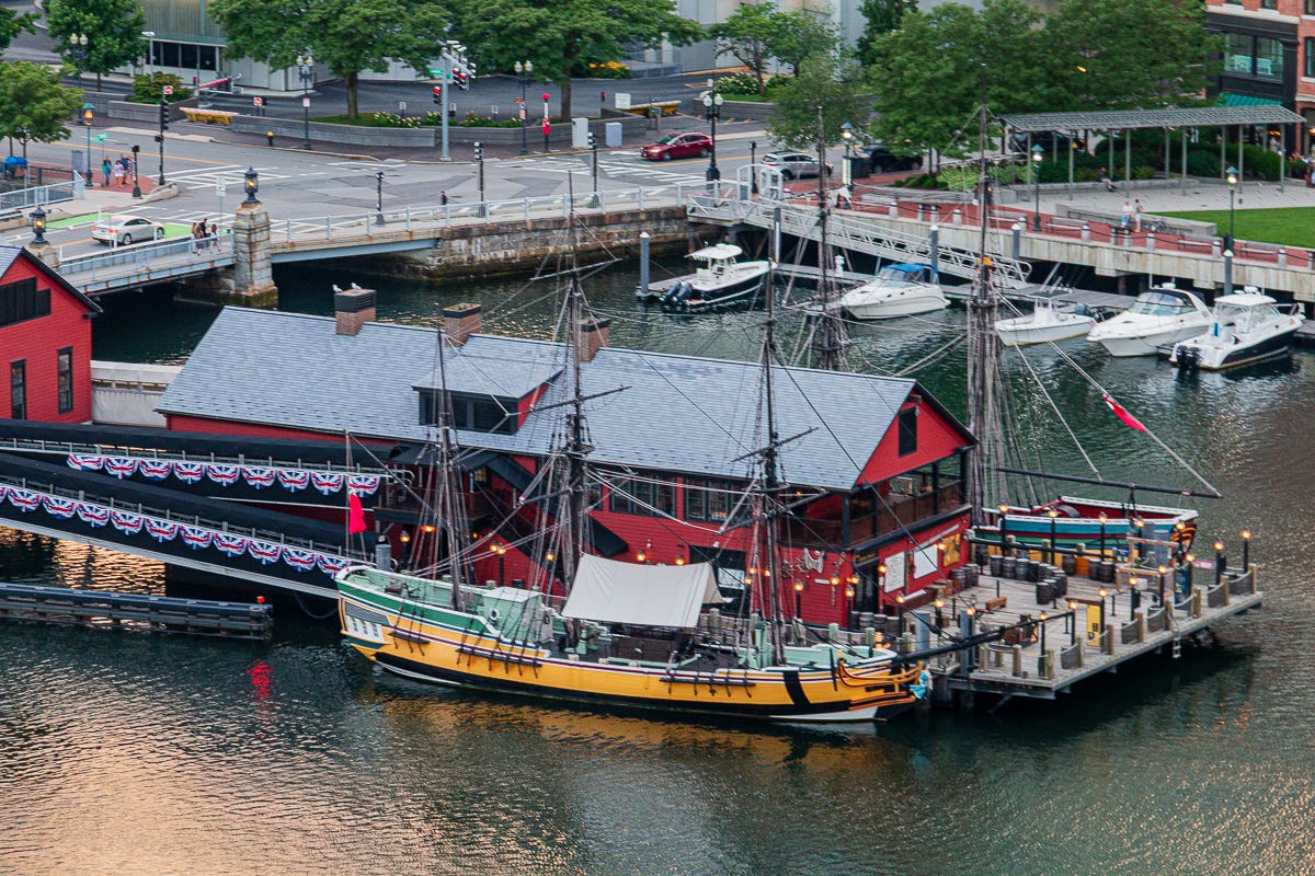 Wide view of Boston Tea Party Ships & Museum with replica tall ships docked in Boston Harbor