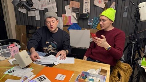 Photos of people around projectors and augmented pieces of paper from the Folk studio