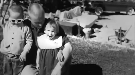 A black and white family photograph, taken outdoors.