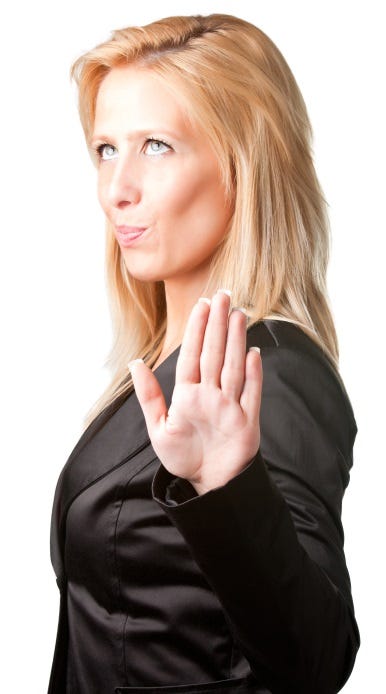 Unimpressed young woman holding up a hand, implying "no".