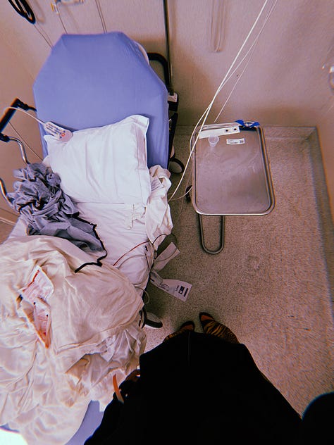 Images for Dr. Cadet in the ER from her braced left thumb adorned with pearls resting on heating packs. Her wrist with a yellow falls risk band, white medical ID band, red allergy band. Blue sheets, white pillow and cream heated blankets on a gurney and covering her like a burrito as she wears a floral mask in her ER room.