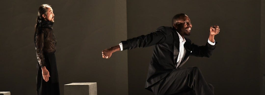 man in black suit sitting on gray chair
