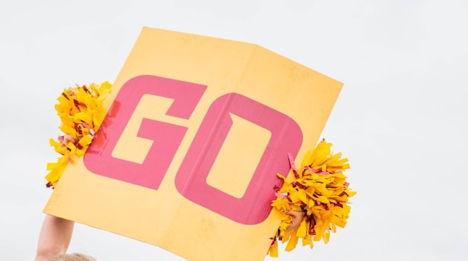 a cheerleader holding a sign in the air