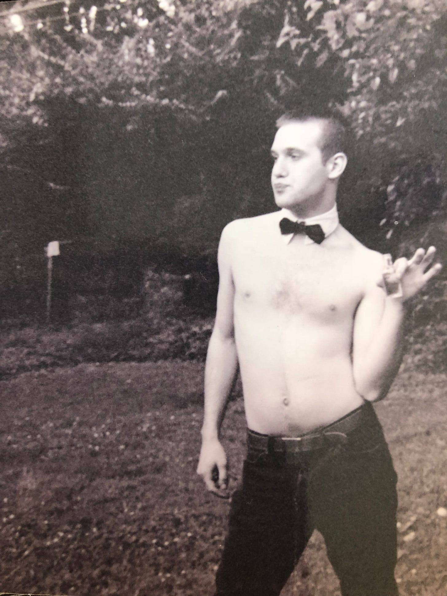 a black and white photograph of my brother, shirtless with a Chippendales collar/tie, holding a mini bottle of alcohol. a black and white photograph of my brother, shirtless with a Chippendales collar/tie, holding a mini bottle of alcohol.