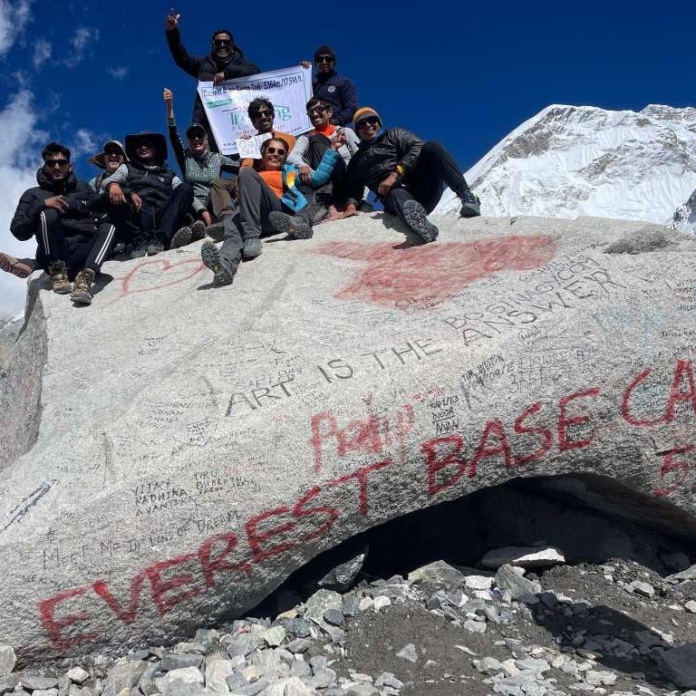 Group of hikers gathered on top of a large rock at Everest Base Camp
