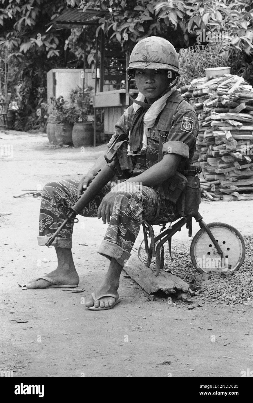 A Cambodian soldier stands guard while sitting on the seat of a ruined  tricycle in an abandoned village on highway 1 southeast of Phnom Penh,  Cambodia Sept. 25, 1973. The highway links