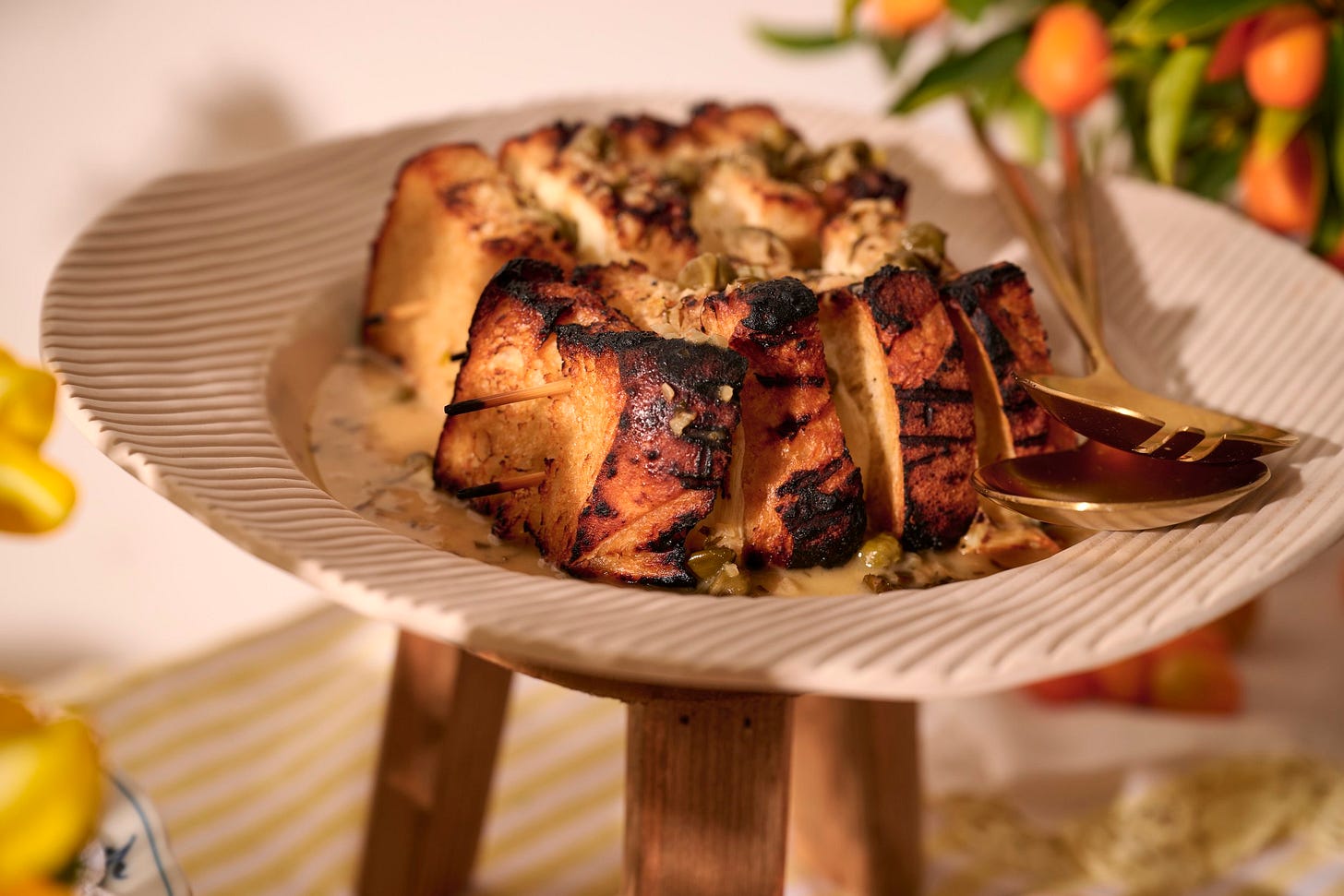 Spiedini alla Romana with grilled bread, melted mozzarella, and anchovy butter sauce on a raised ceramic platter Spiedini alla Romana with grilled bread, melted mozzarella, and anchovy butter sauce on a raised ceramic platter