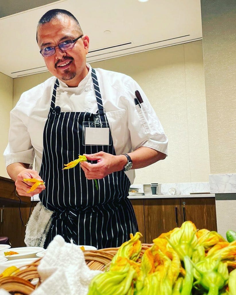 chef Nephi Craig in a black and white striped apron prepping food in the kitchen
