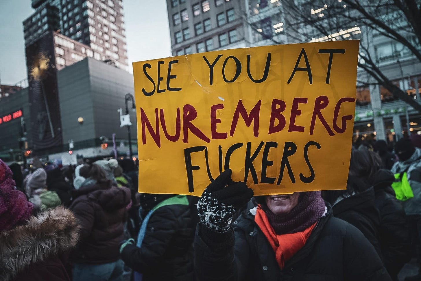 A protest sign says "See You At Nuremberg Fuckers" A protest sign says "See You At Nuremberg Fuckers"