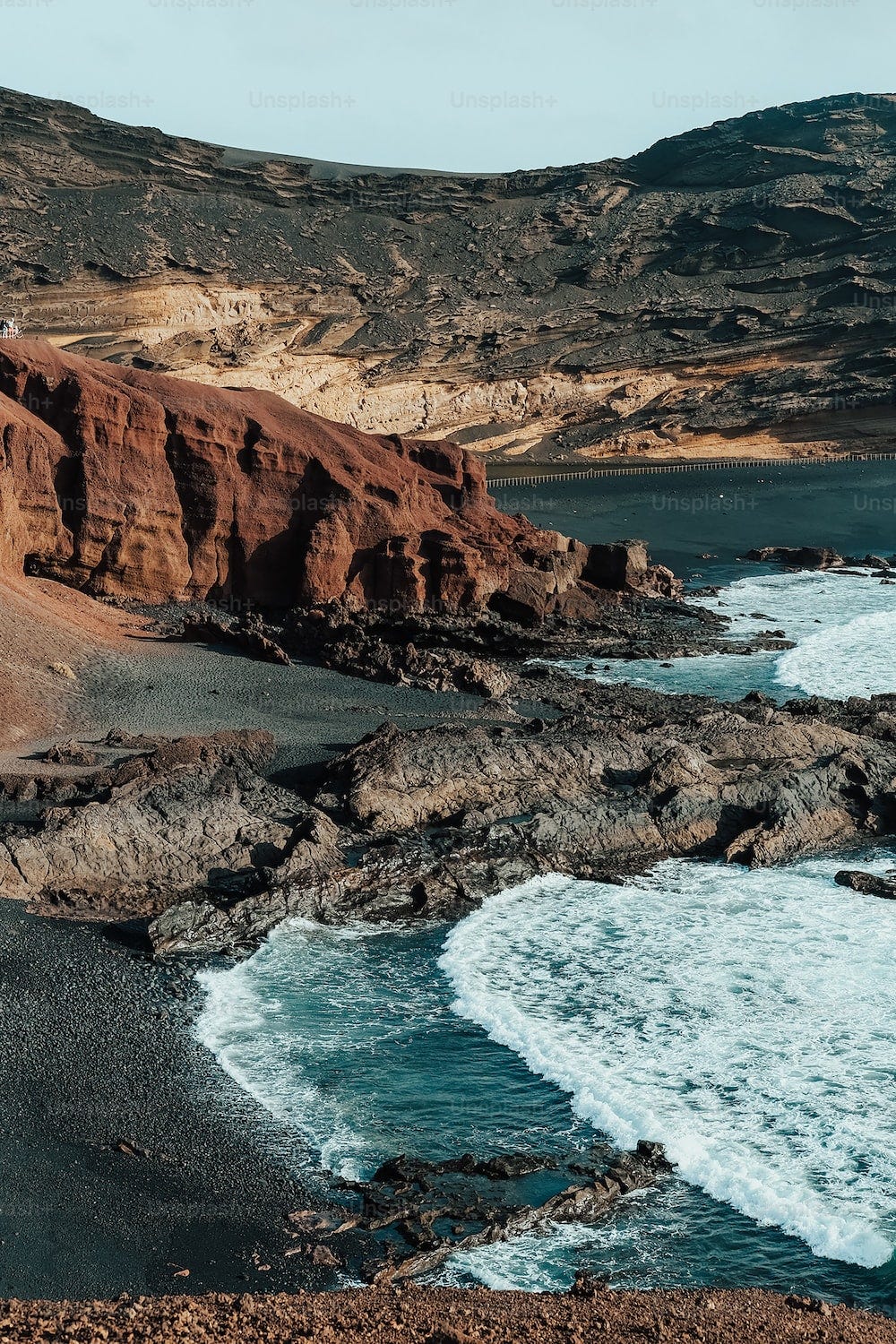 a rocky beach with a body of water next to it a rocky beach with a body of water next to it