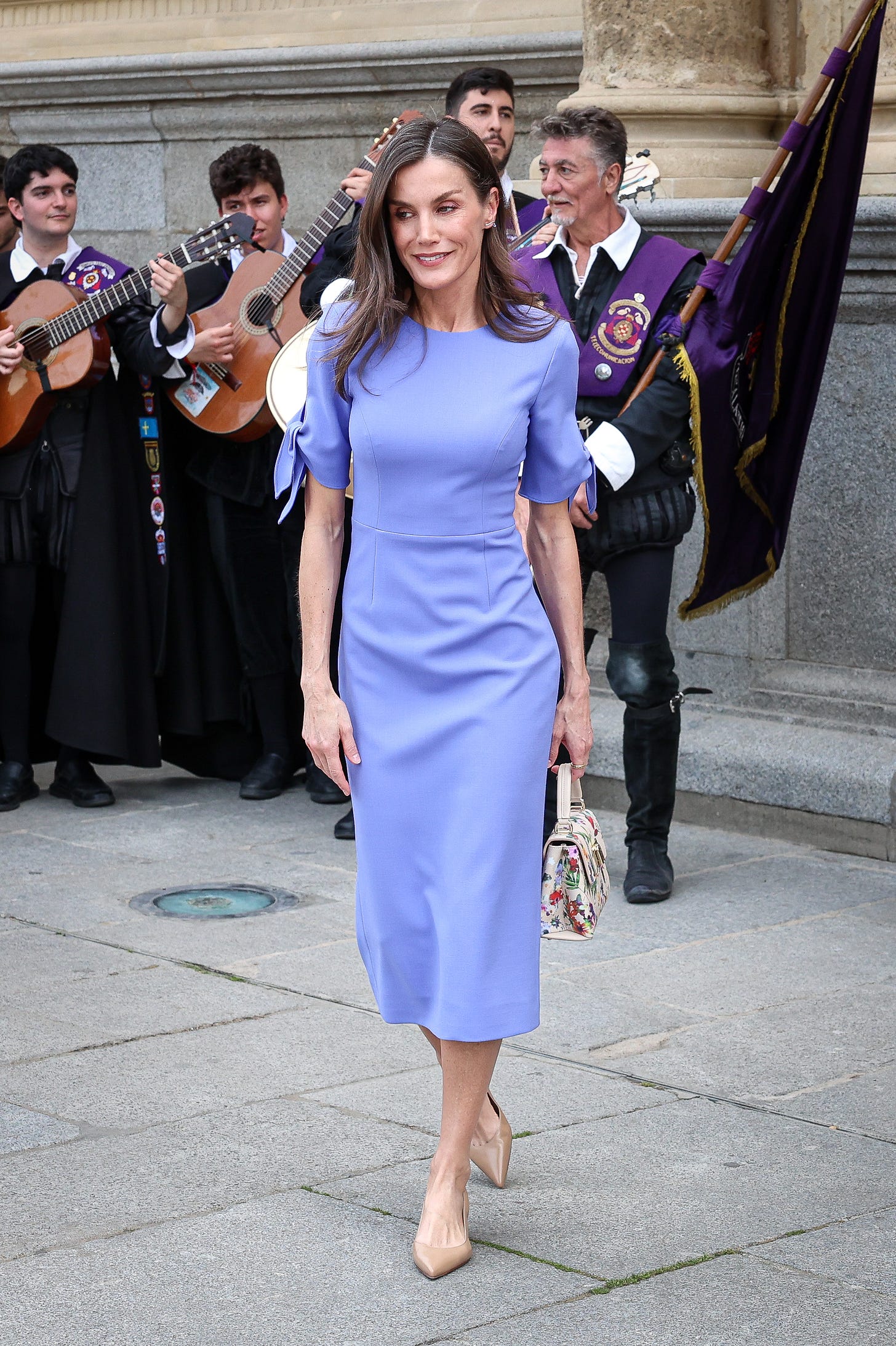 Queen Letizia smiling wearing a violet dress