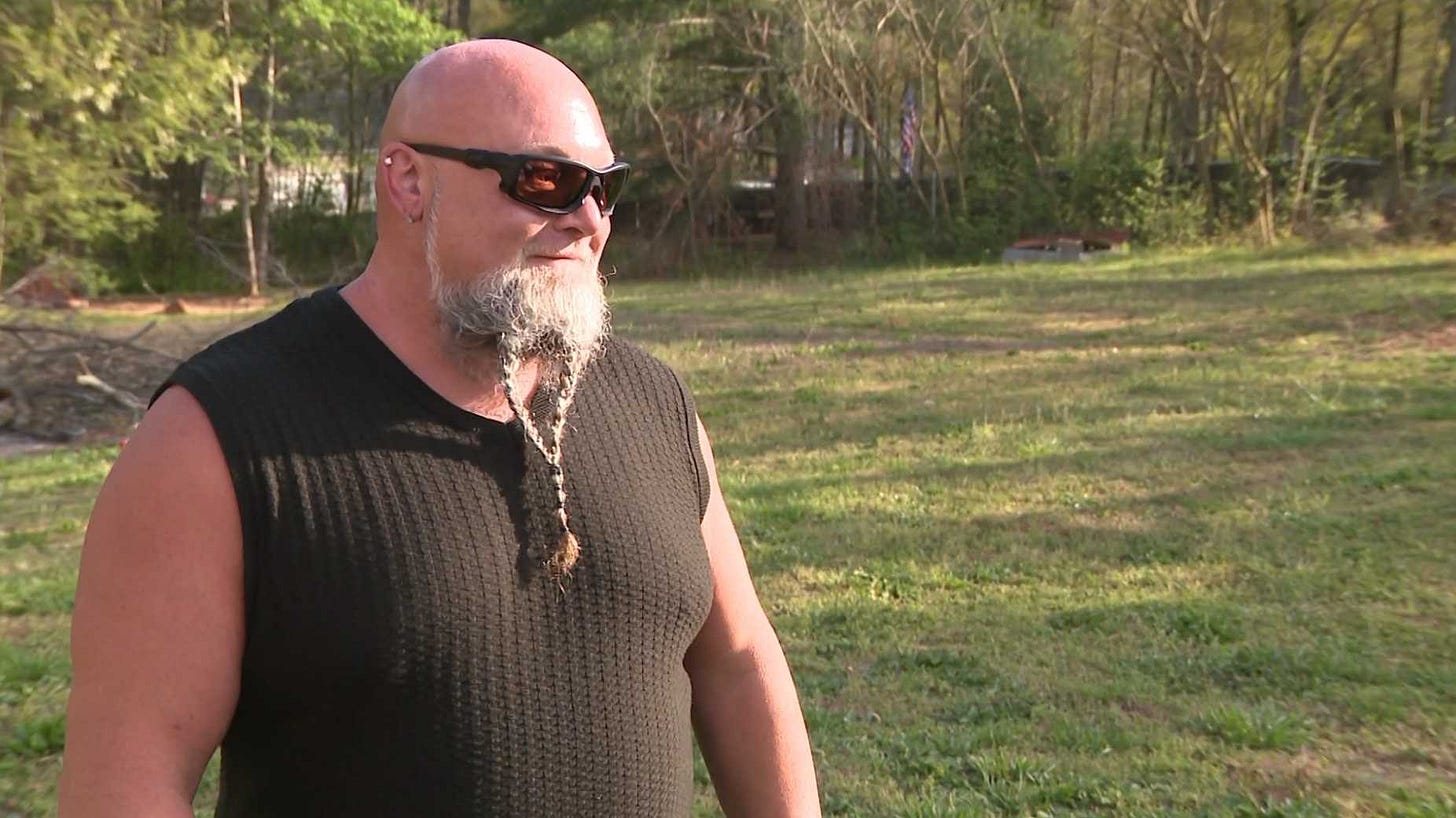 A man stands in a backyard