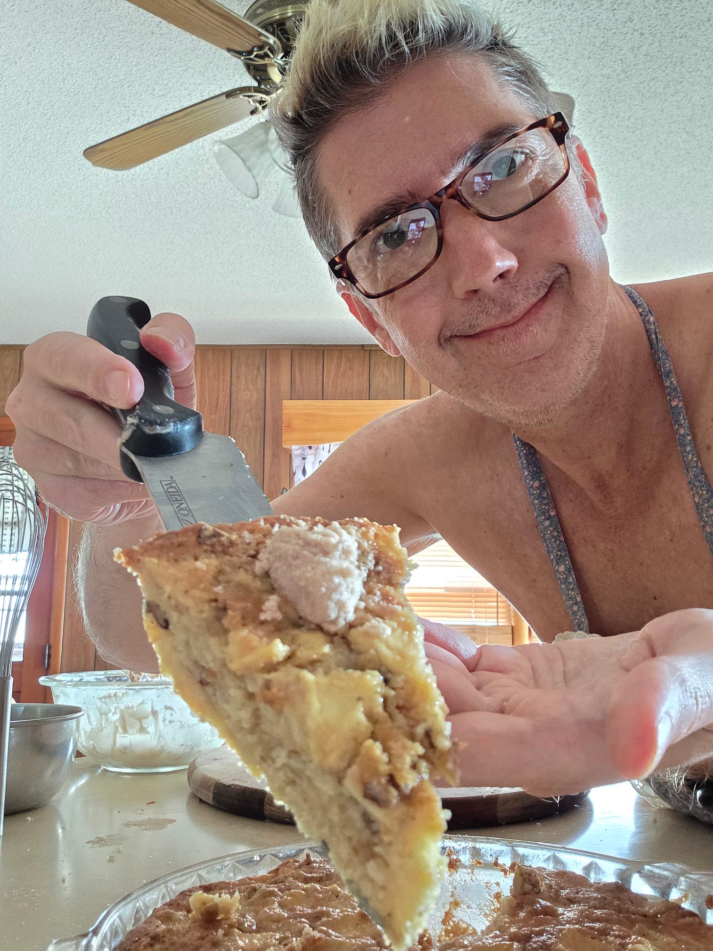 author wearing an apron holding a slice of Apple Myster Dessert author wearing an apron holding a slice of Apple Myster Dessert