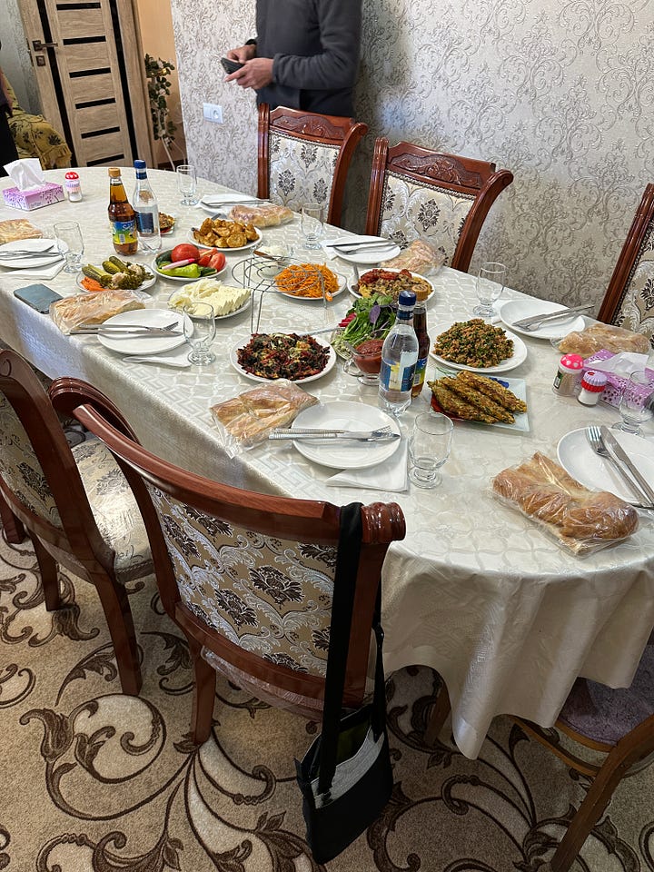 Picture of a landscape view beyond an arch, and a table spread with food