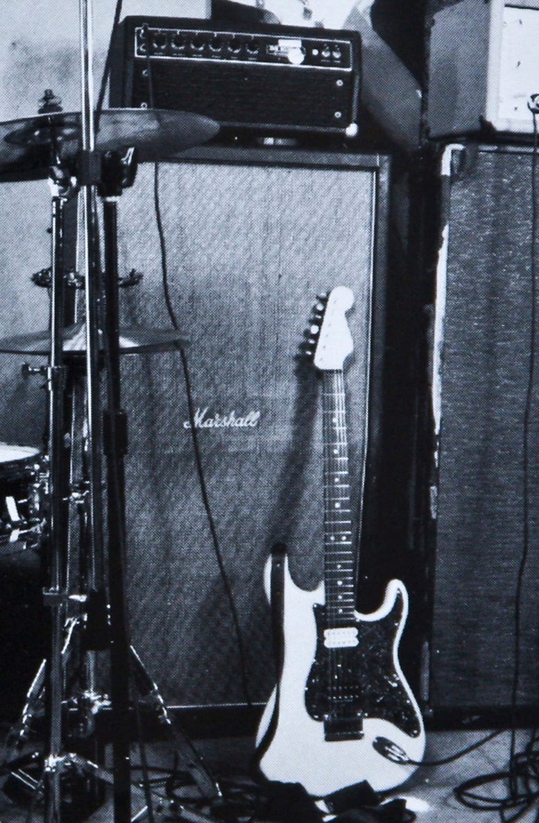 A monochrome image showcasing a guitar and amplifier, captured in black and white.