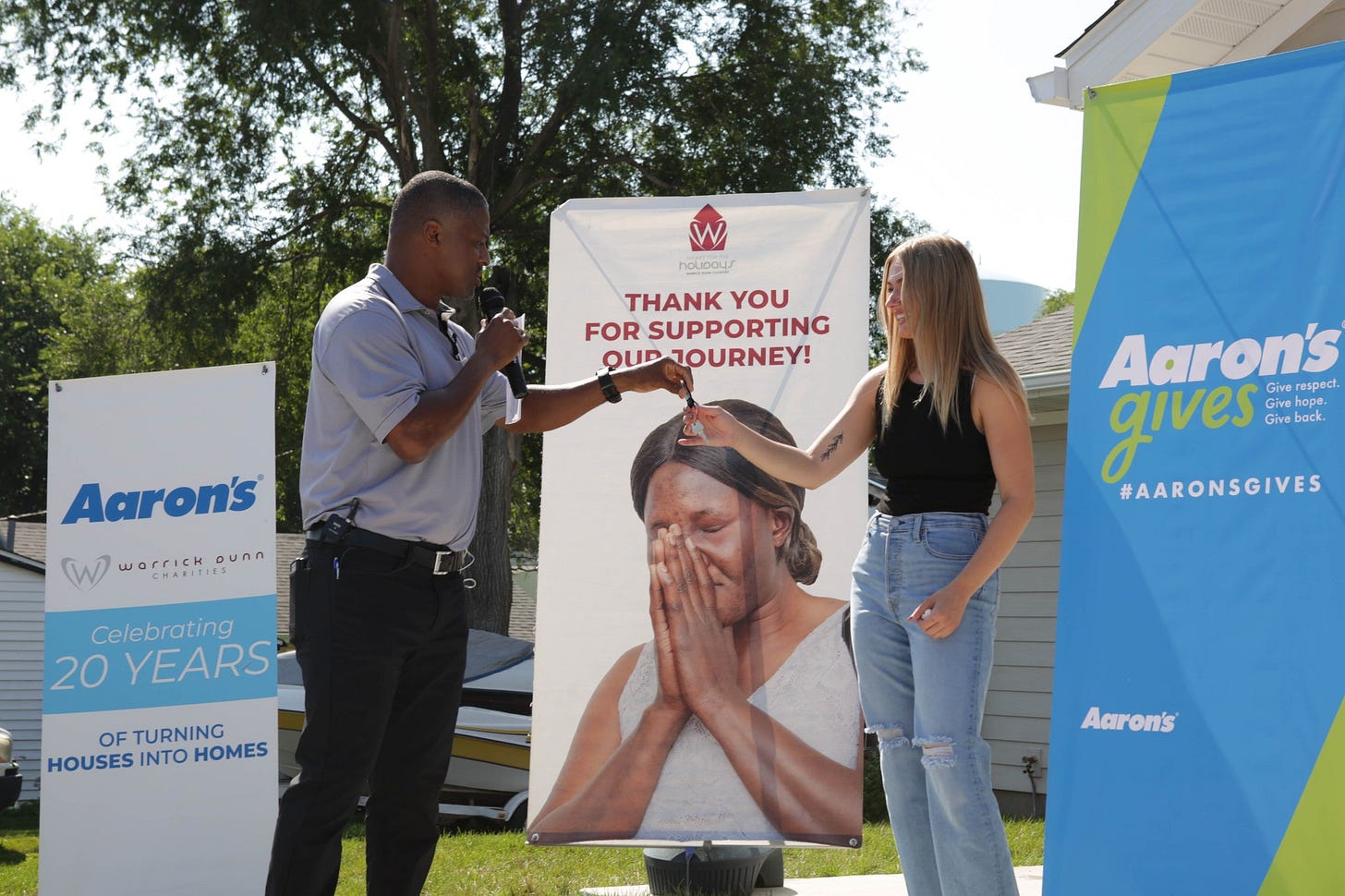 May be an image of 2 people and text that says 'houoaus THANK THANKYO YOU FOR SUPPORTING OUD JOURNEY! Aaron's W War warrickounn ounn Aaron's Give respect. qives gives Give back. Give #AARONSGIVES Celebrating 20 YEARS OFTURNING OF HOUSES INTO HOMES Aaron's'