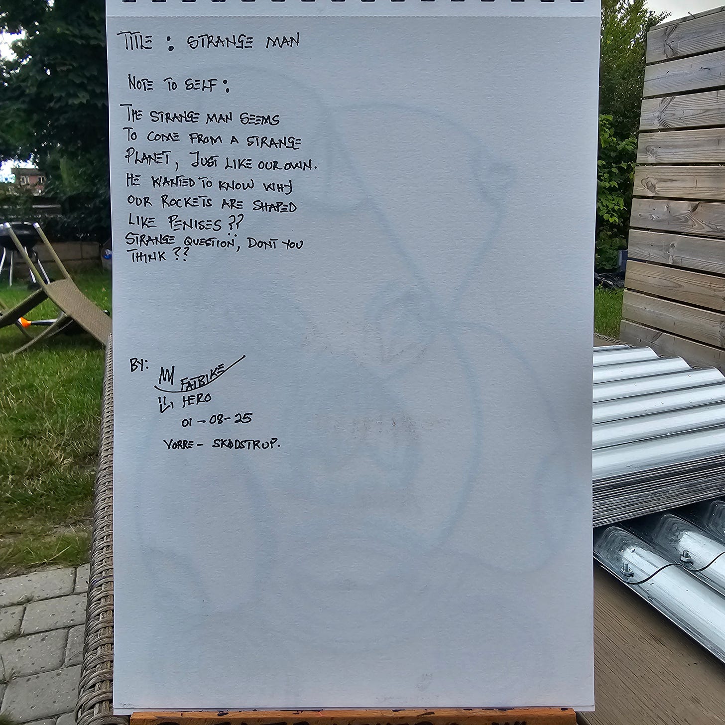 Handwritten sketchbook notes by Fatbikehero titled "Strange Man." The text discusses an alien visitor questioning why human rockets resemble phalluses. Dated 01-08-25, Vorre-Skodstrup.