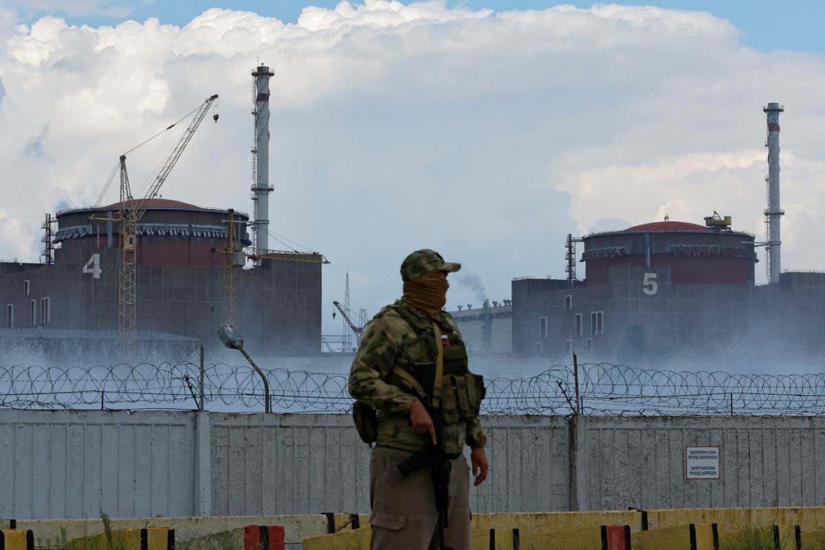 A serviceman with a Russian flag on his uniform stands guard near the Zaporizhzhia Nuclear Power Plant in the course of Ukraine-Russia conflict outside the Russian-controlled city of Enerhodar in the Zaporizhzhia region, Ukraine August 4, 2022. REUTERS/Alexander Ermochenko - RC2LPV9MUYER A serviceman with a Russian flag on his uniform stands guard near the Zaporizhzhia Nuclear Power Plant in the course of Ukraine-Russia conflict outside the Russian-controlled city of Enerhodar in the Zaporizhzhia region, Ukraine August 4, 2022. REUTERS/Alexander Ermochenko - RC2LPV9MUYER