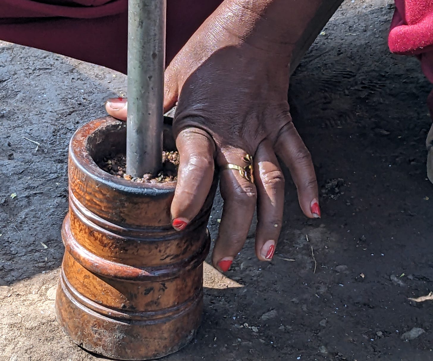 A black woman is grinding coffee by hand with a mortar and pestle. We don’t see her face. A black woman is grinding coffee by hand with a mortar and pestle. We don’t see her face.