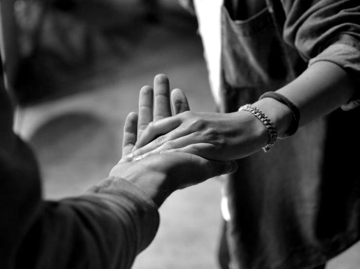 man and woman holding hands on street