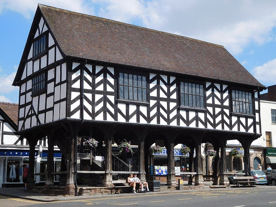 Ledbury Market House, a black-and-white timbered Tudor-style building with a peaked roof, raised above street level by wooden posts 