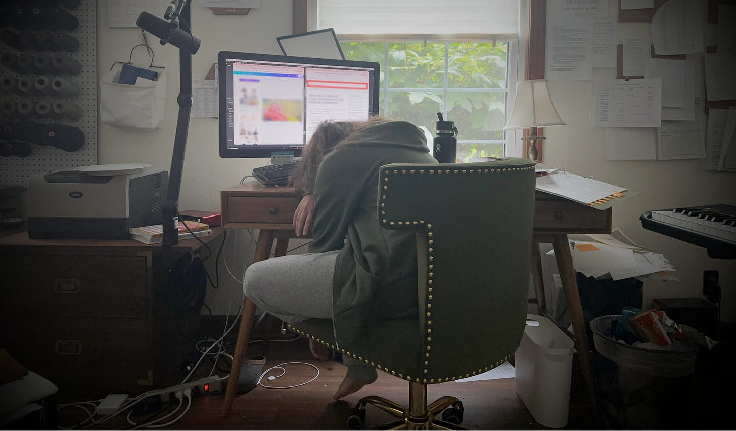 Carrie slumps face-down on her desk surrounded by her chronically messy home office (ADHD shutdown)