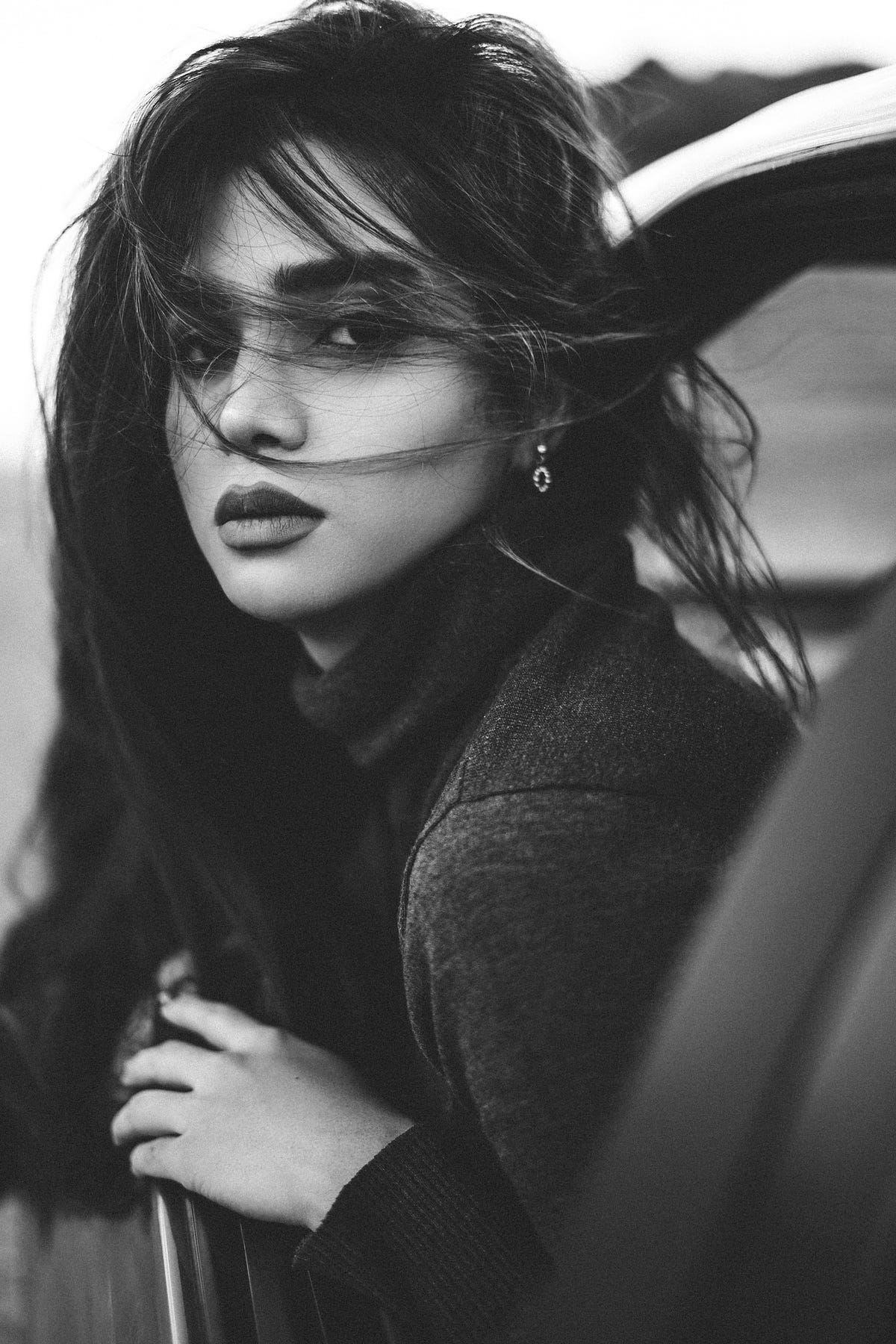Black and white photo of a beautiful woman gazing out a car window, wind in her hair, her face full of quiet emotion — the kind that comes from letting go of a story that once felt like love but never fully arrived. Black and white photo of a beautiful woman gazing out a car window, wind in her hair, her face full of quiet emotion — the kind that comes from letting go of a story that once felt like love but never fully arrived.