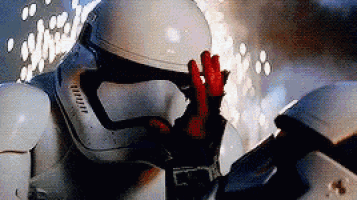 a storm trooper is waving his hand in the air while wearing a helmet and gloves . a storm trooper is waving his hand in the air while wearing a helmet and gloves .