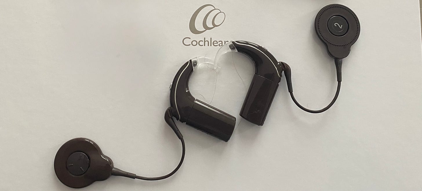 Une nouvelle version de mes deux implants cochléaires de couleur marron qui sont côte à côte et forment un coeur. En arrière plan, la couleur blanche et on voit la marque Cochlear. Une nouvelle version de mes deux implants cochléaires de couleur marron qui sont côte à côte et forment un coeur. En arrière plan, la couleur blanche et on voit la marque Cochlear.