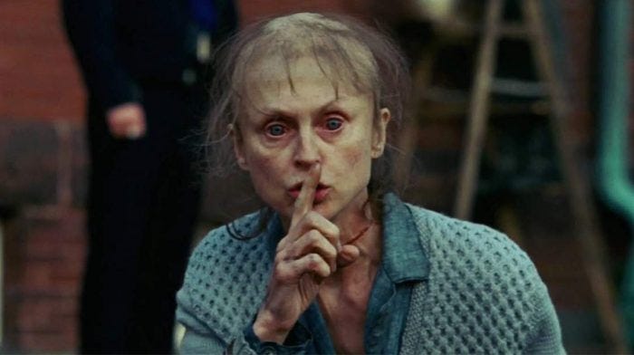 Creepy woman making "shh" gesture in Shutter Island.