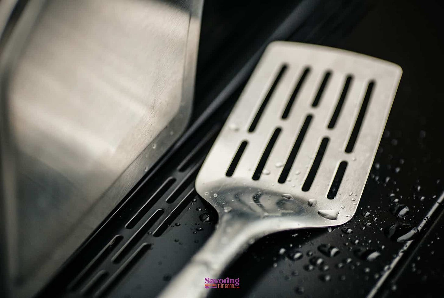 A metal spatula on a stove top.