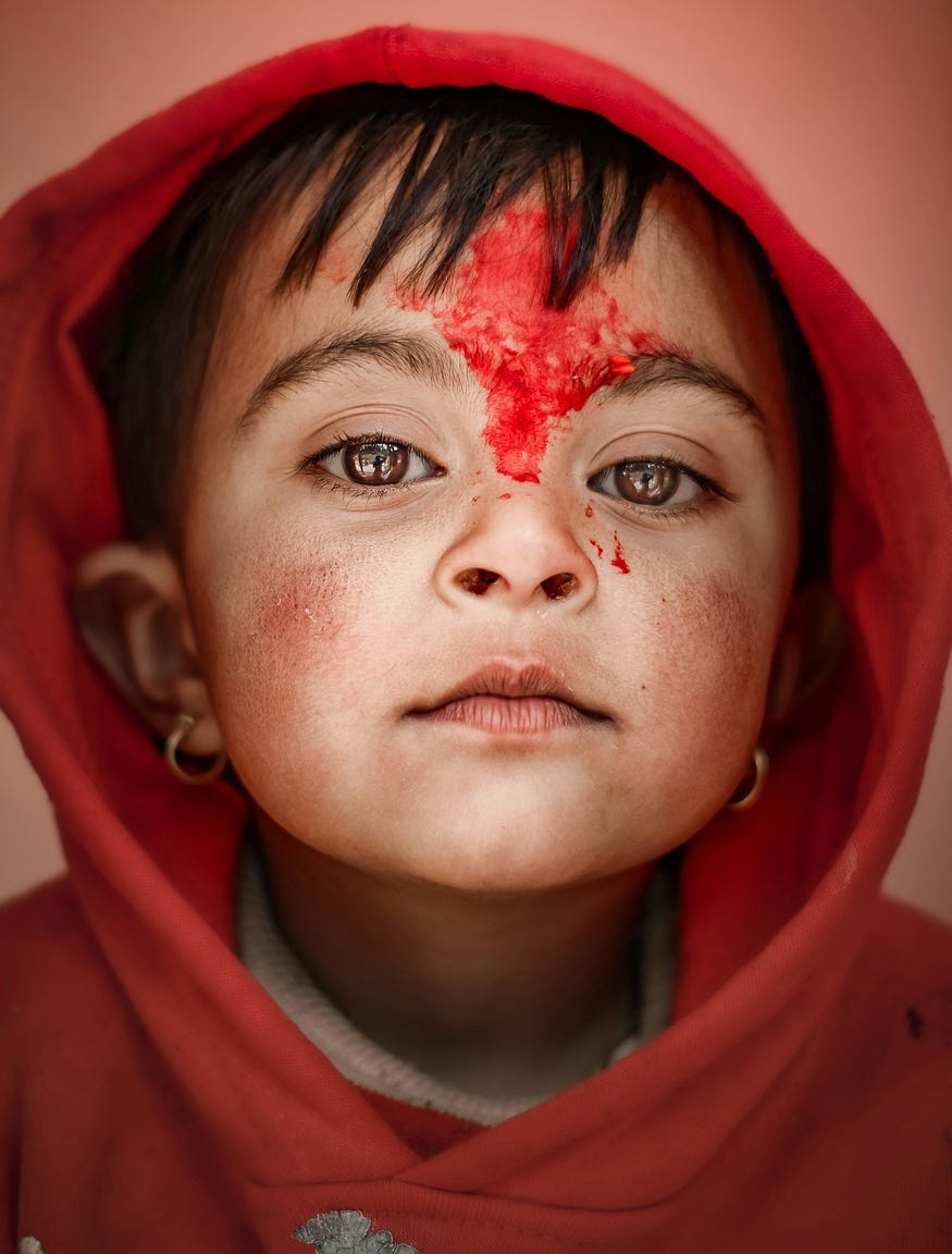 A girl in a red hoodie with red fluid smeared on her face