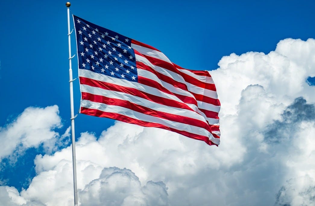 An american flag flying high in the sky An american flag flying high in the sky