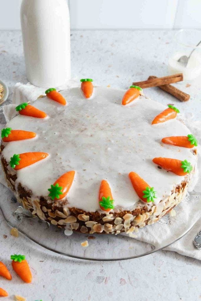 Saftiger Karottenkuchen steht auf einem Kuchenteller am Tisch.