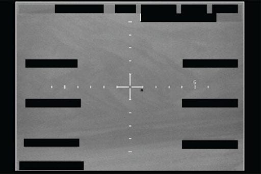 A tactical infrared FLIR sensor display from a fighter jet cockpit showing a small unidentified aerial object tracked in the center of the crosshairs.