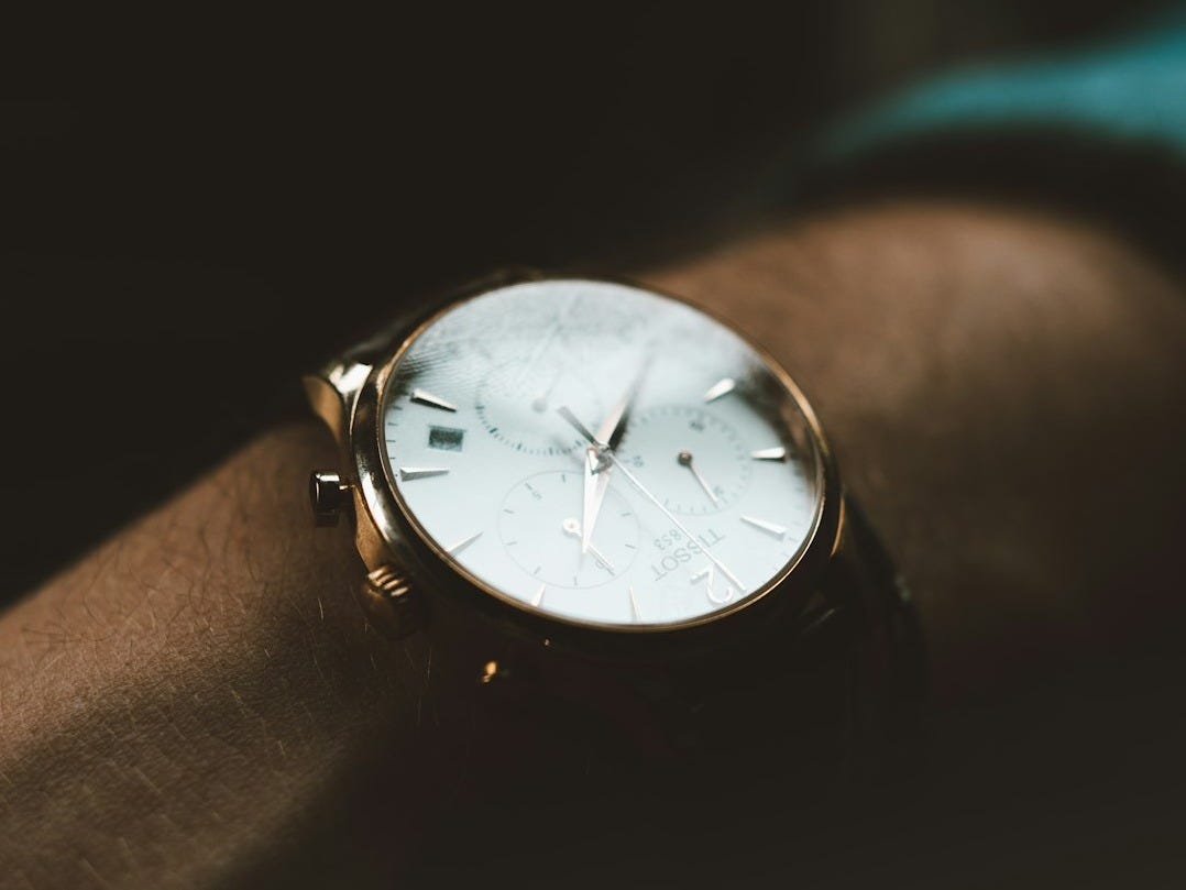 person wearing white chronograph watch