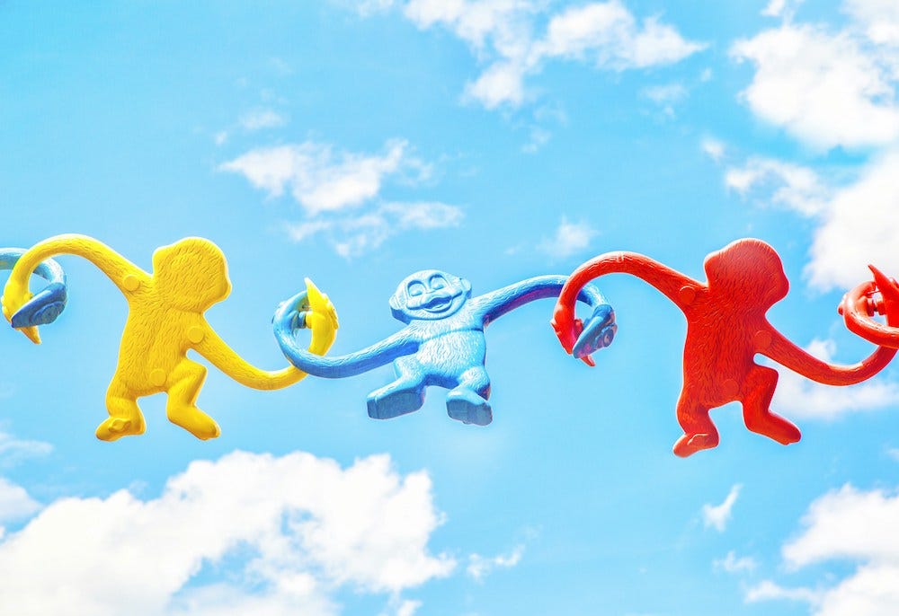 colorful linked armed monkey toys with blue sky background